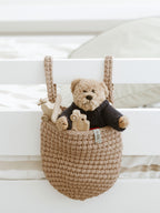 Beige crocheted hanging crib pocket organiser filled with nursery toys – Anzy Home
